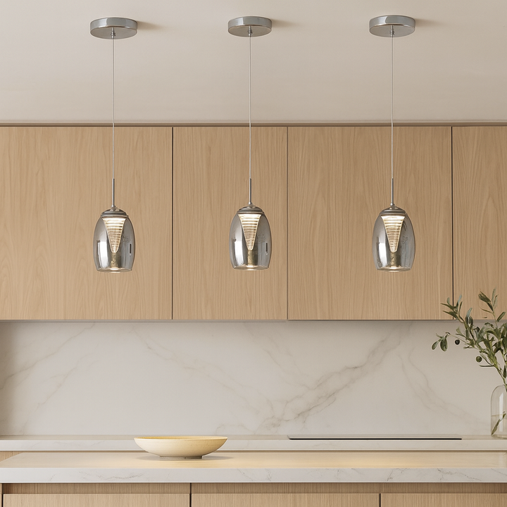 Three Adelaide smoked glass pendant lights attached to the ceiling above a luxury marble kitchen island with wood cabinets