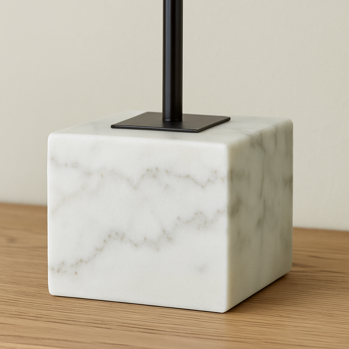 Close-up of the Adele Table Lamp marble base with black stem, styled on a wooden surface.