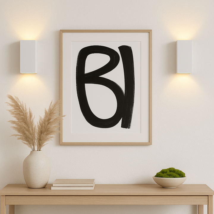 Pair of Adelong white rectangular wall lights framing black and white abstract artwork above a console table with pampas vase, books, and a green moss bowl.