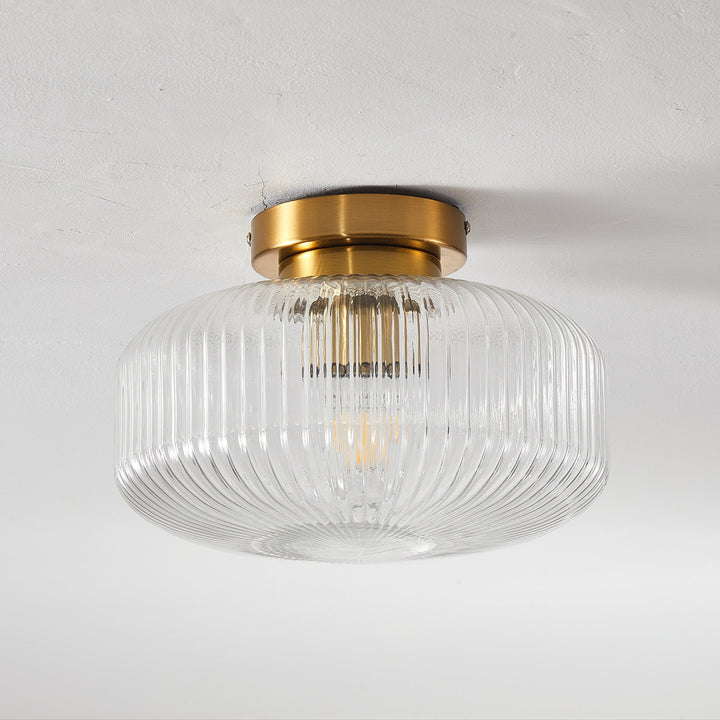 Ceiling light fixture with glass shade and gold finish on a white background