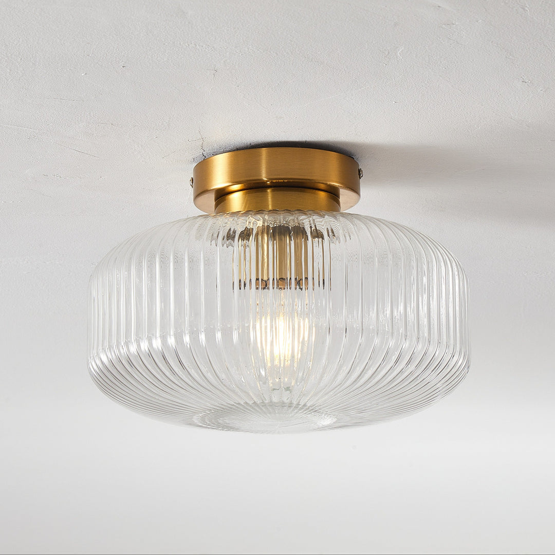Ceiling light fixture with glass shade and gold trim on a white background