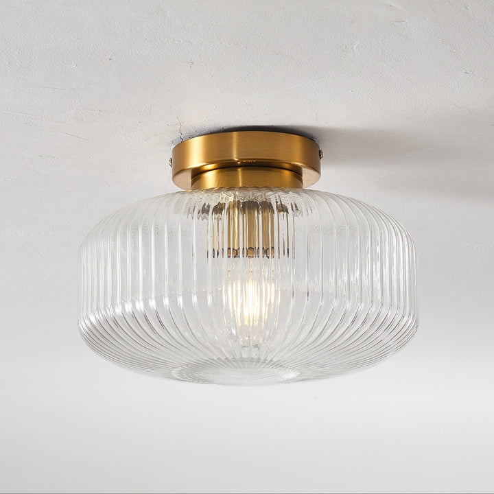 Ceiling light fixture with glass shade and gold trim on a white background