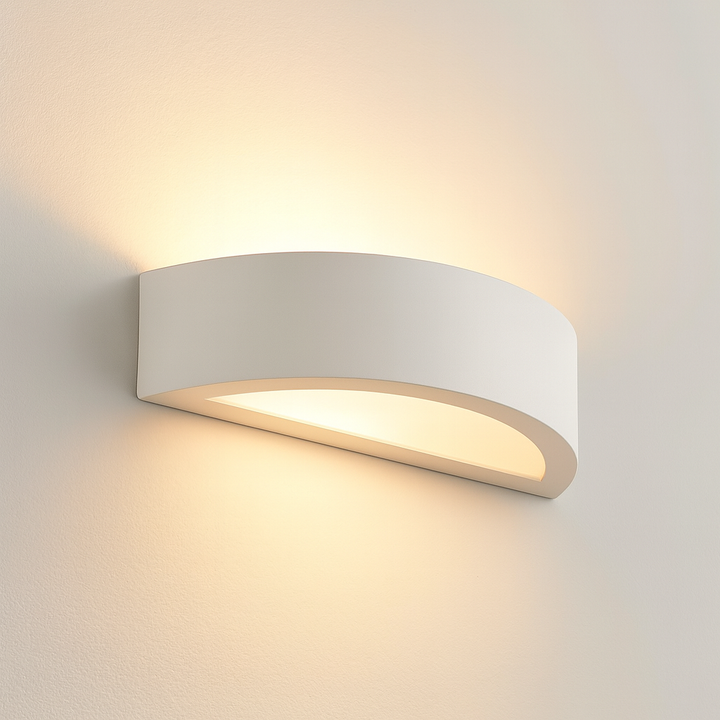 Bega wall light in a smooth white finish, mounted on a white wall with warm upward and downward glow.