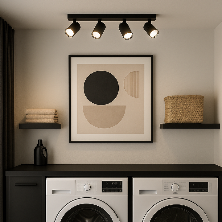 Modern black 4-light spotlight bar on ceiling in a stylish utility room with black countertop, abstract wall art, and laundry appliances.