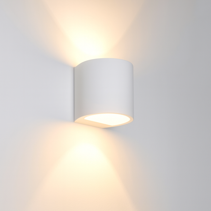 Capel white ceramic wall light with up and down glow on a white wall