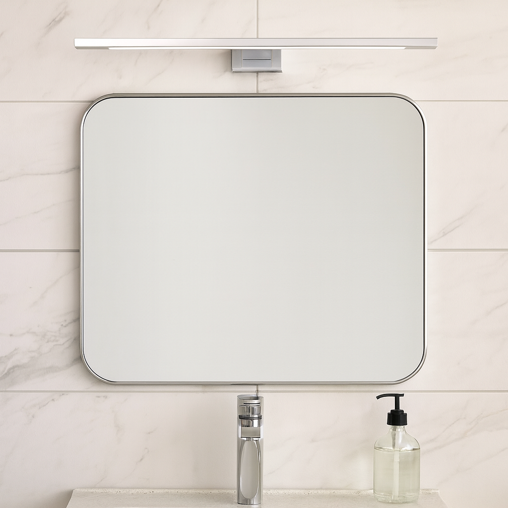 Chrome bathroom wall light mounted above a modern mirror in a marble-tiled bathroom