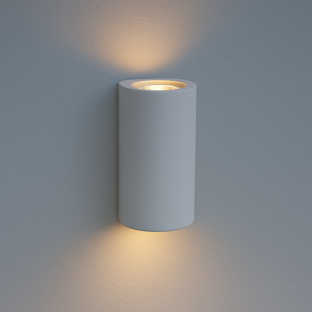 Modern cylindrical white wall light glowing up and down in soft early evening daylight on a neutral wall.