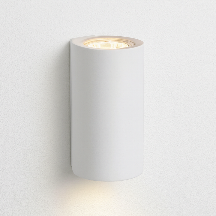 Denham modern white cylindrical wall light on a clean white wall background