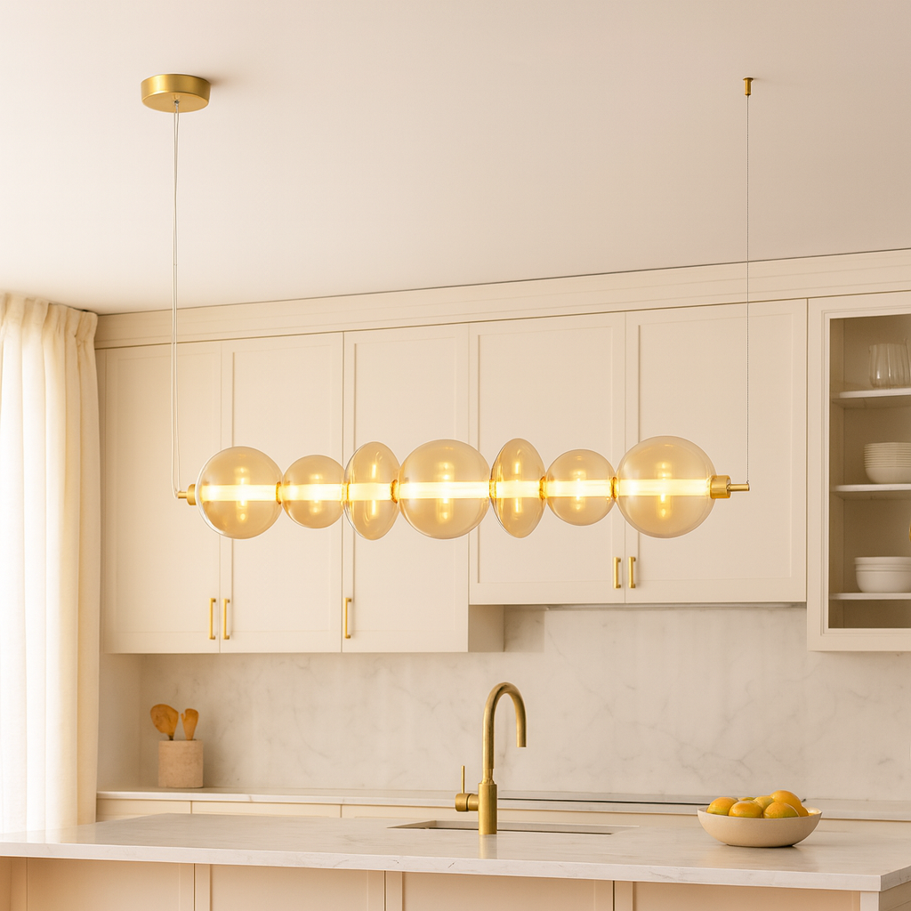 Europa Lighting gold glass pendant bar light hanging in a modern kitchen with cream cabinets and gold accents.