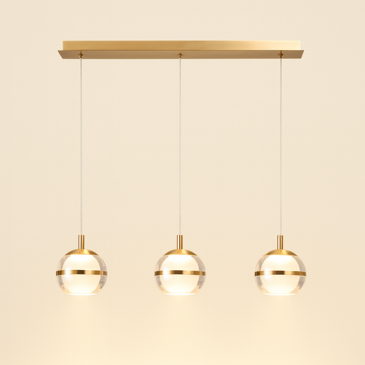 Gold trim 3 light glass pendant bar with light background.