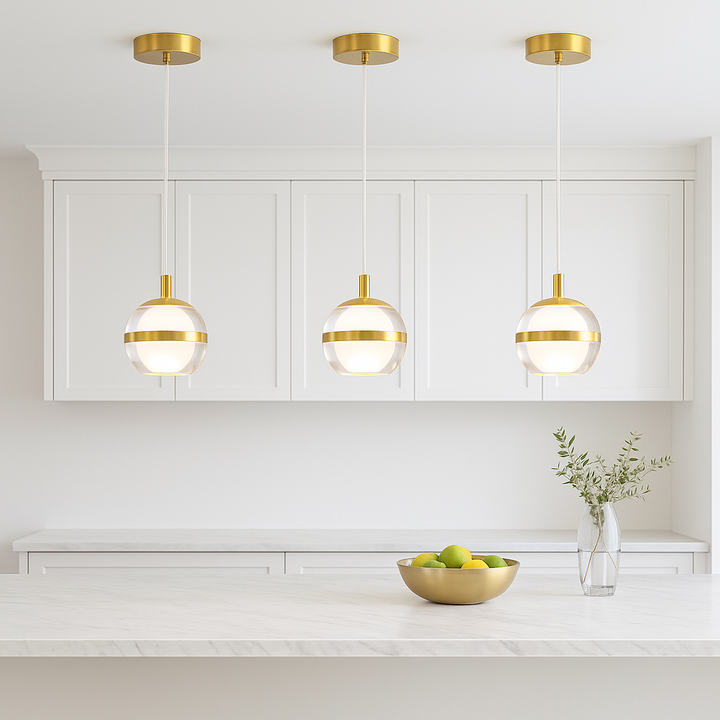 Gold 3 light glass pendant above modern marble kitchen island