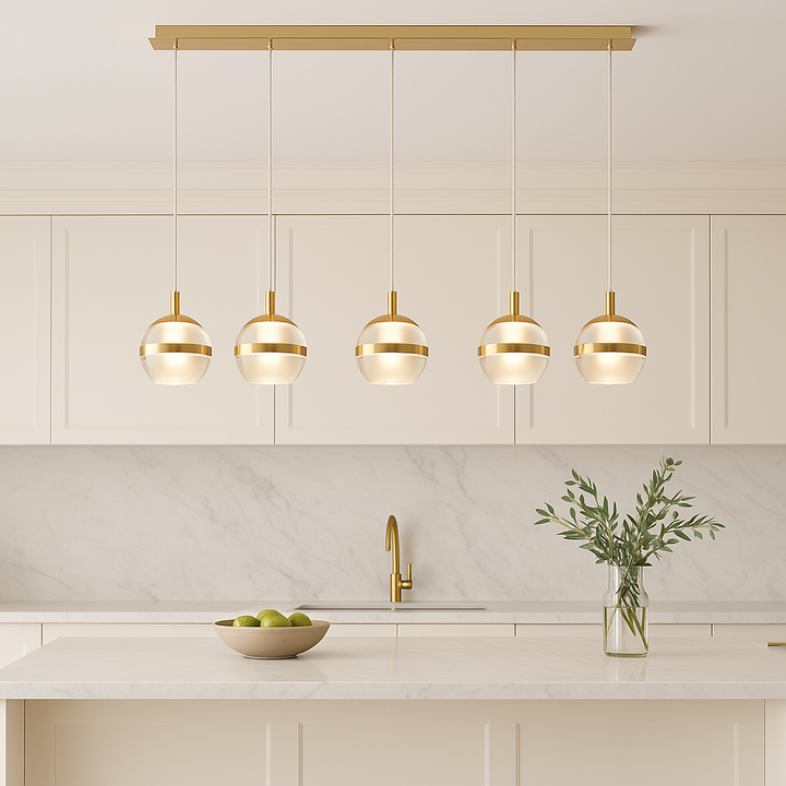 Luxury gold 5 light pendant bar with glass globe shades styled above a modern white marble kitchen island with gold accents