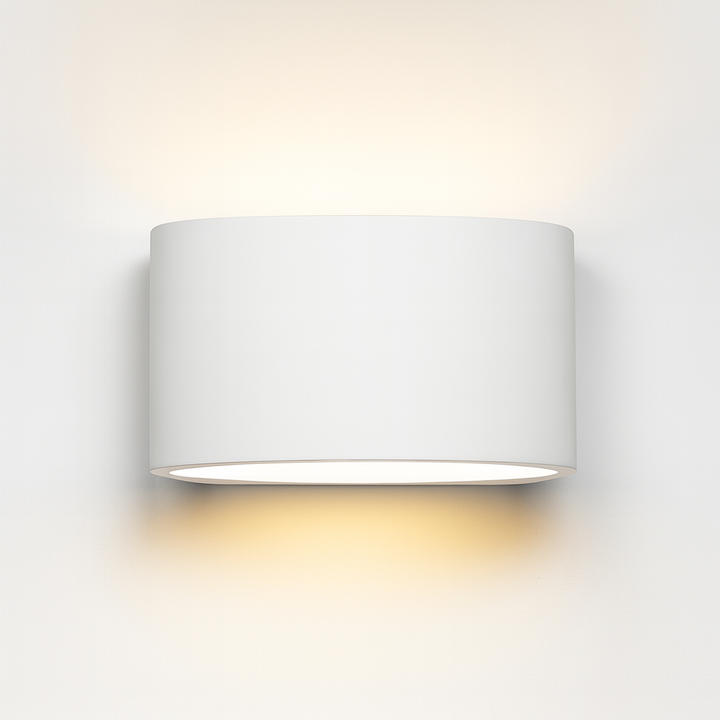 Midland ceramic wall light with smooth cylindrical design, paintable finish, and warm up-and-down glow on a white background