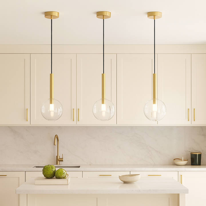 Modern white kitchen with gold accents featuring three 20cm glass globe pendant lights hanging proportionally over a small island.
