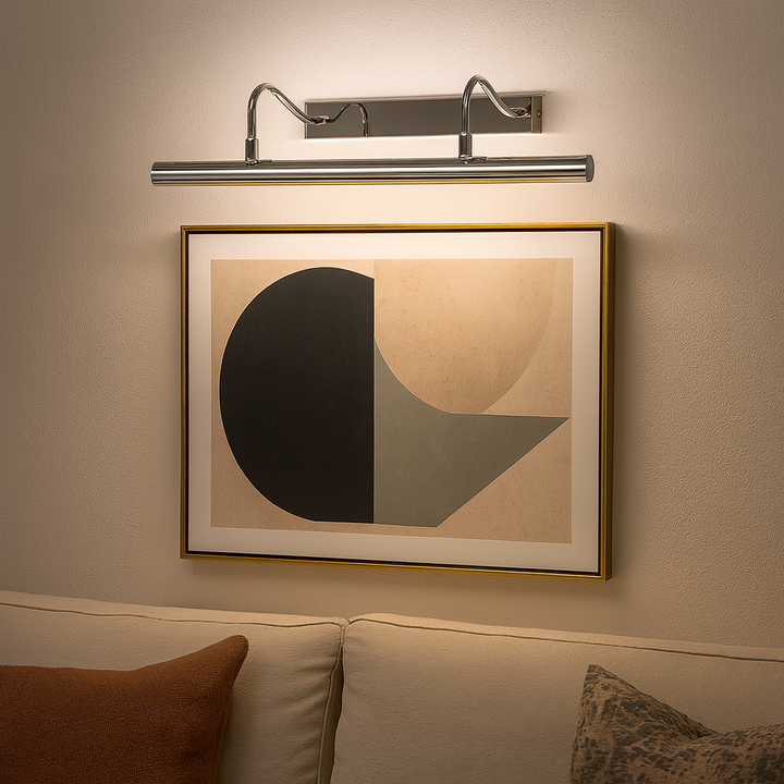 Polished chrome picture wall light 49cm wide illuminating framed modern abstract artwork above a sofa
