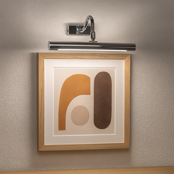 Polished silver picture wall light 28cm wide illuminating framed modern abstract artwork on a grey wall