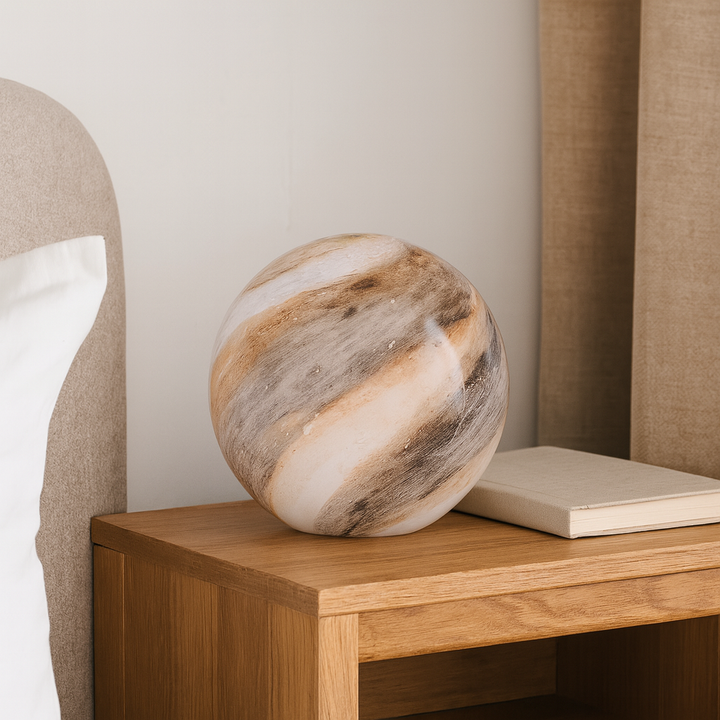Round marble effect glass table lamp in taupe and brown swirl finish, 23.5cm tall x 25cm wide, styled on a wooden bedside table