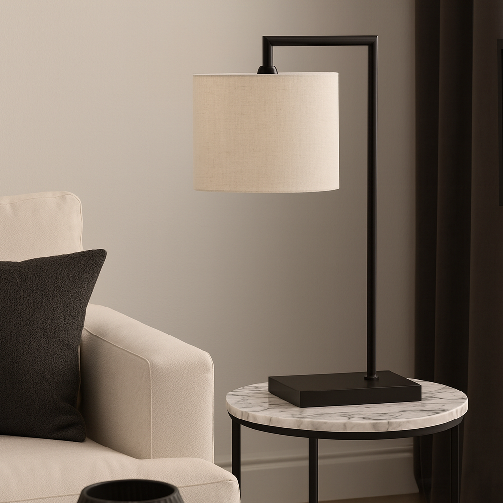 Modern black table lamp with 25cm white fabric shade on a round marble side table beside a neutral sofa in a luxury living room.