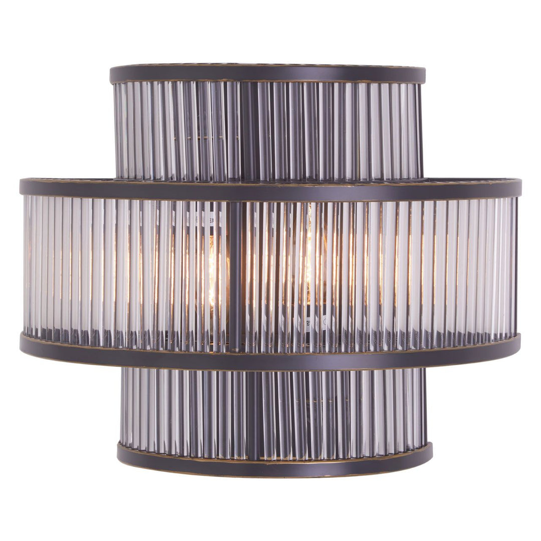 A modern wall light fixture with a black finish and bronze highlights, featuring a cylindrical shape with clear glass rods.