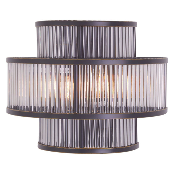 A modern wall light fixture with a black finish and bronze highlights, featuring a cylindrical shape with clear glass rods.