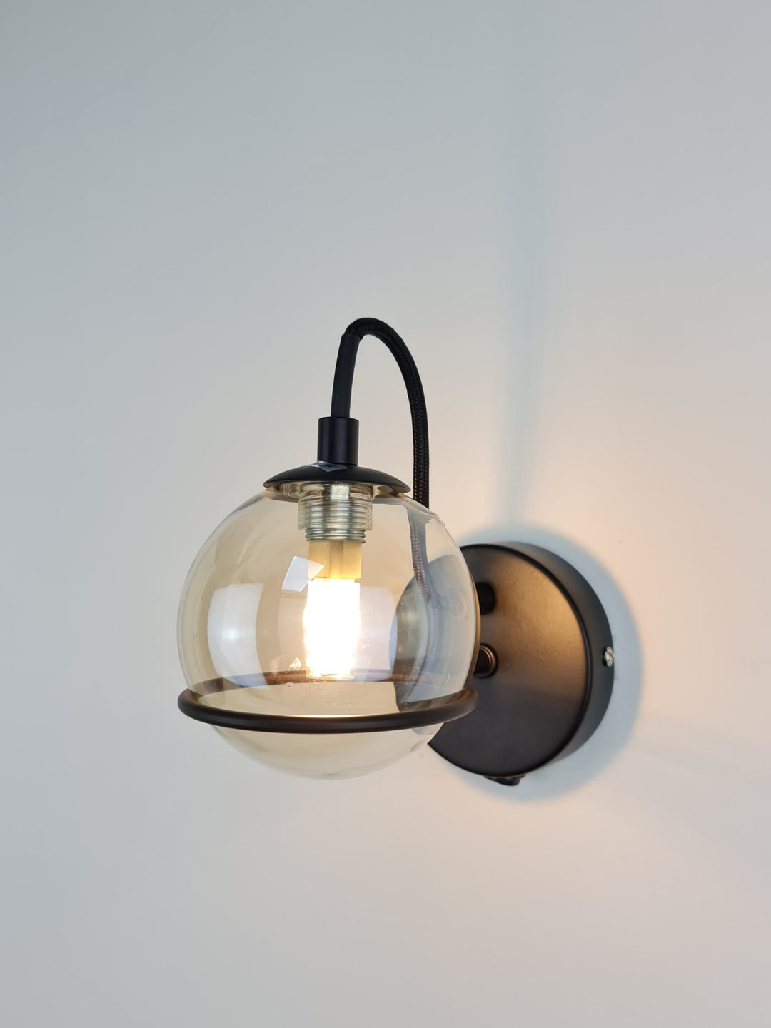 Melville matt black wall light amber glass shade