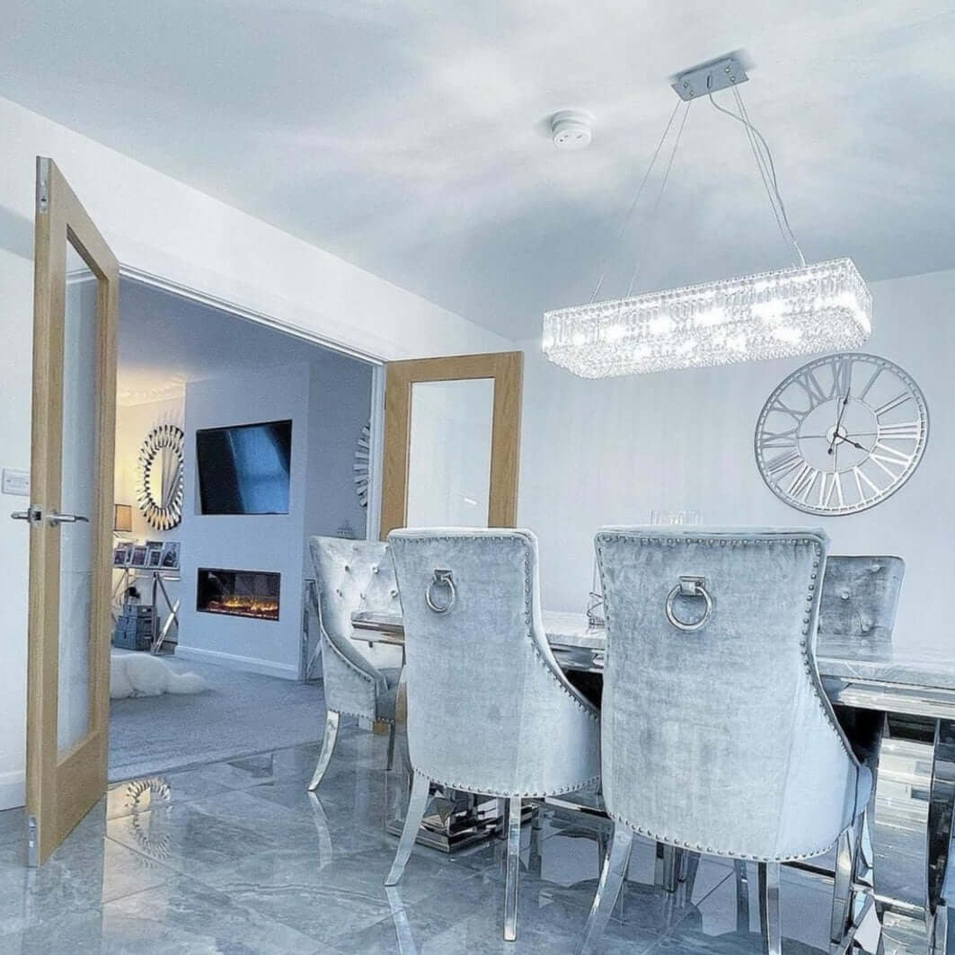 Salzburg rectangular chandelier with crystal and chrome design, styled above a luxury dining table.