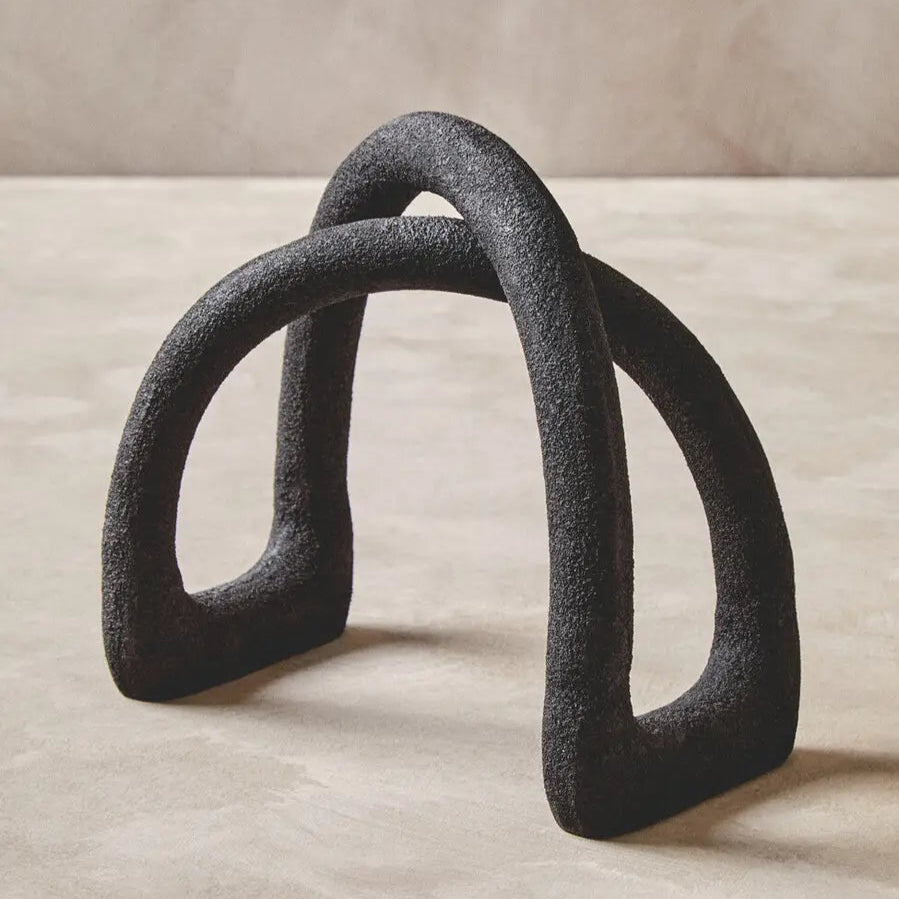 Black abstract sculpture on a beige surface