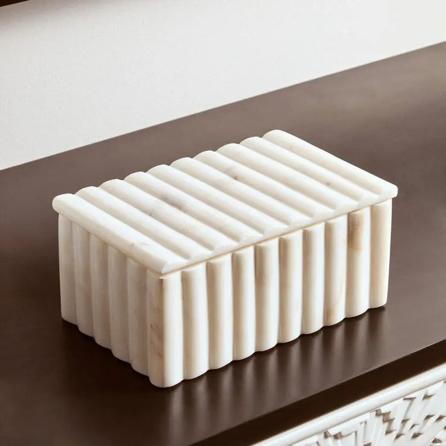 Rectangular ceramic box with ribbed texture on a dark surface