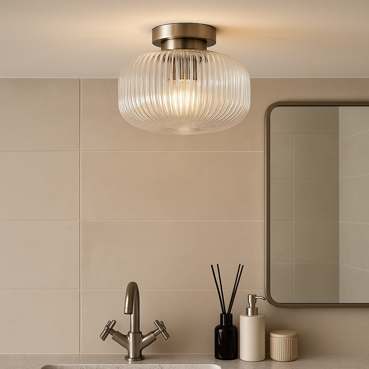 Arlo nickel flush ceiling light with ribbed clear glass shade in a luxury bathroom, styled with nickel tap, mirror, and modern accessories.