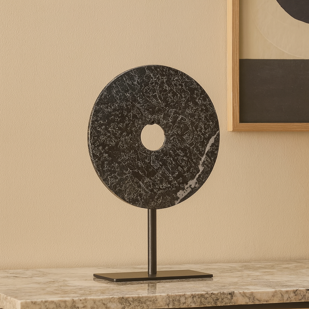 Black marble disc sculpture on stand styled on a luxury sideboard with neutral décor – modern decorative accessory