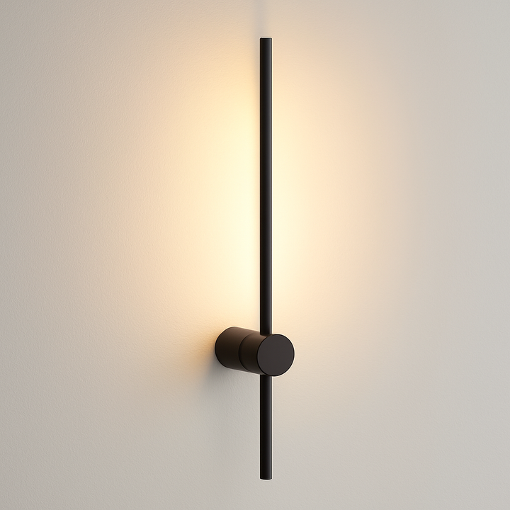 Modern black stick wall light, 60cm long, mounted on a white wall with warm glow