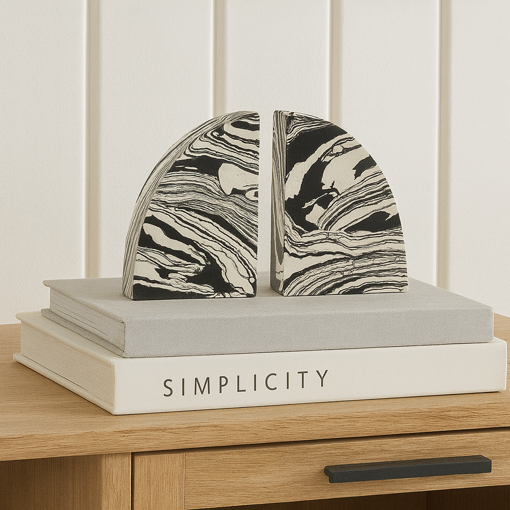 Pair of black and white marble effect bookends styled on a Nordic media wall unit with modern coffee table books.