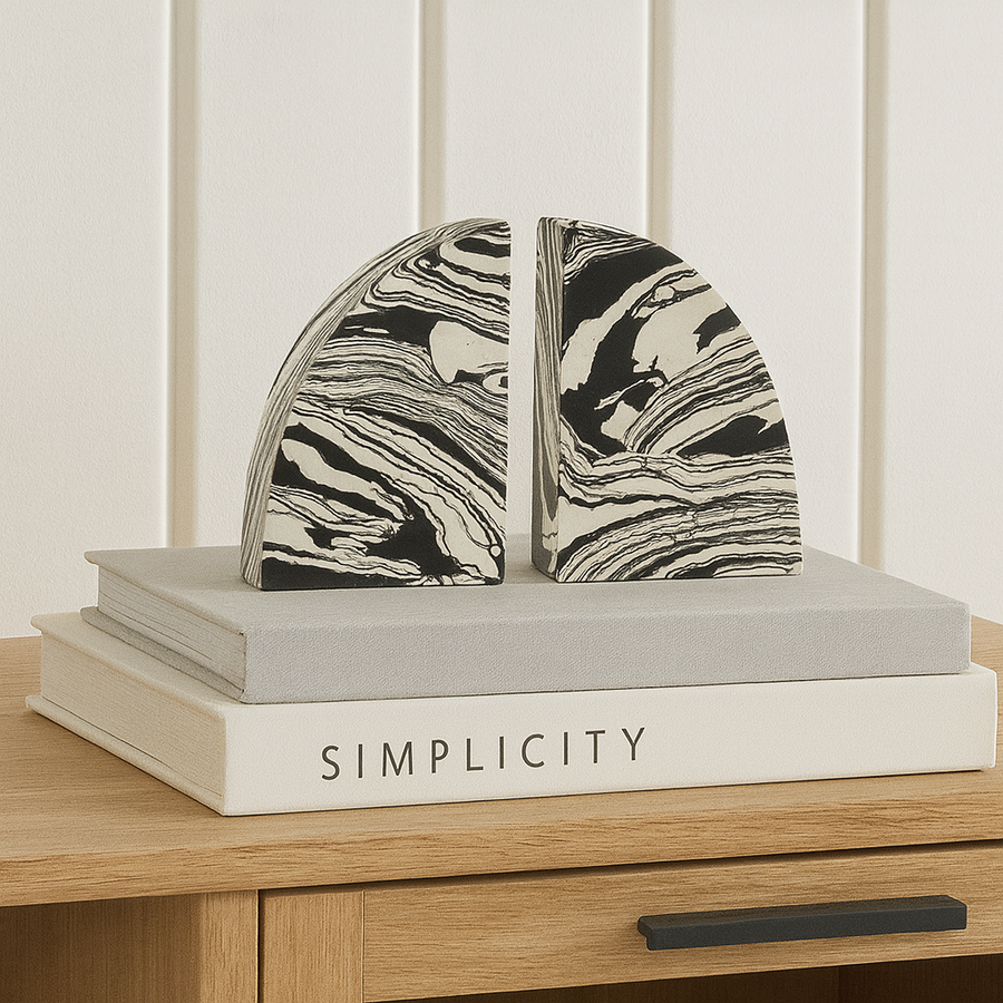 Pair of black and white marble effect bookends styled on a Nordic media wall unit with modern coffee table books.