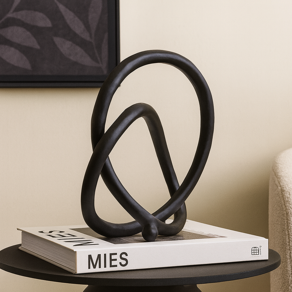 Luxury black metal loop sculpture modern home décor accessory on coffee table book