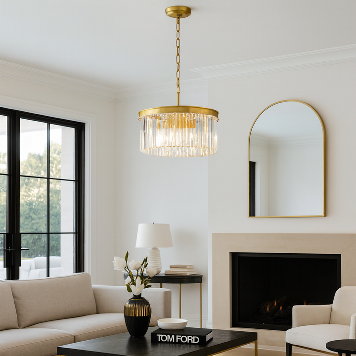 Luxury living room with Carolina gold round crystal chandelier attached to ceiling, styled with modern cream sofas, black coffee table, and gold accents