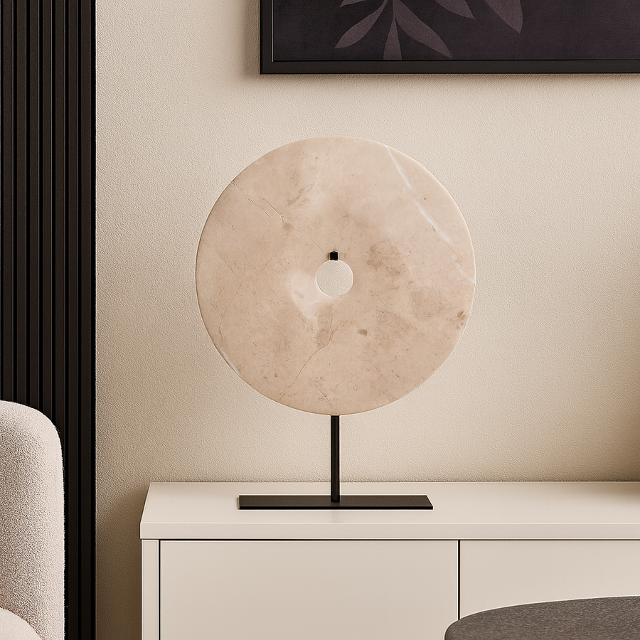 Large beige marble disc sculpture on black stand luxury home décor for sideboard or media wall styling