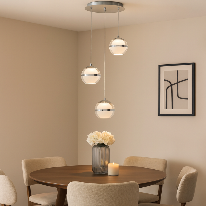 Luxury 3 light spiral pendant in chrome and glass styled above a modern round dining table with neutral décor
