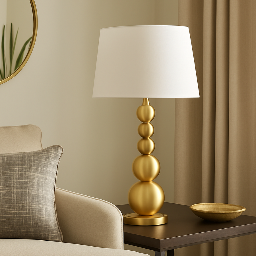 Luxury gold sphere table lamp with white shade styled on a console table in a modern living room with neutral décor
