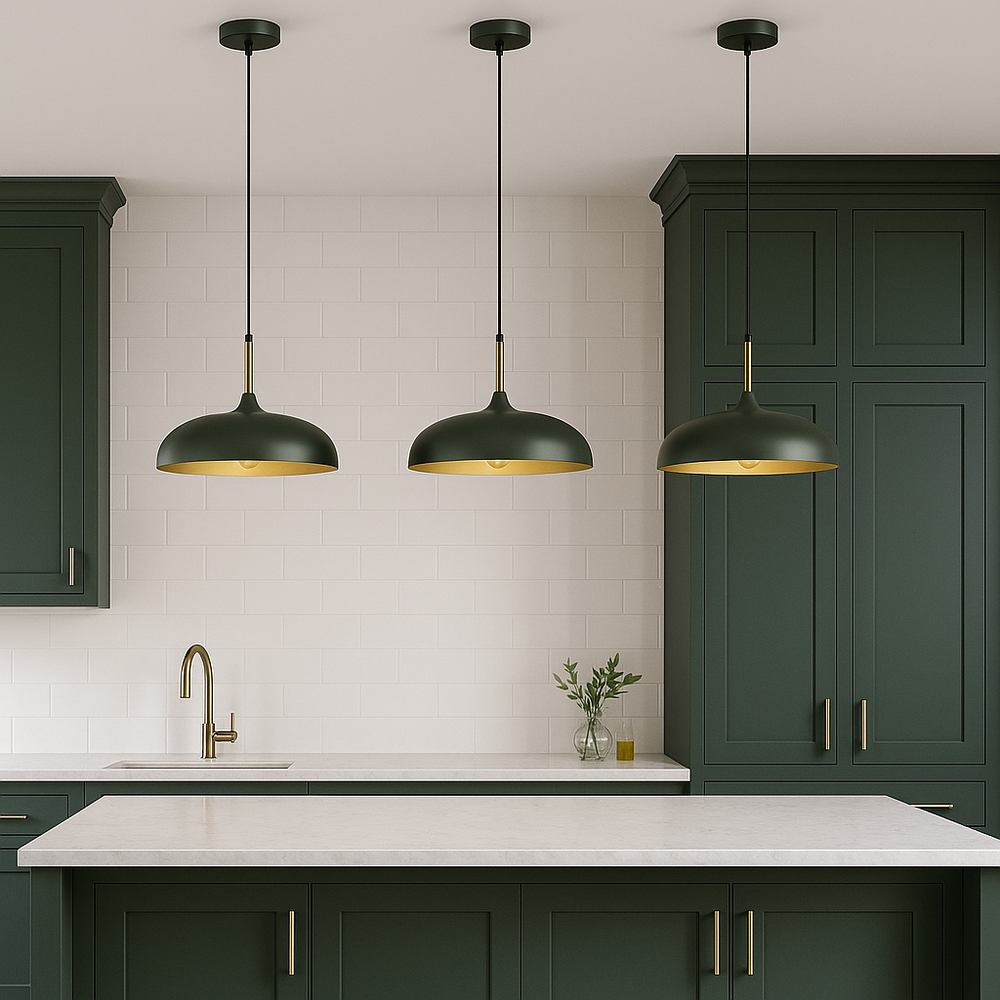 Luxury kitchen with three green and gold pendant lights over marble island, green shaker cabinets with gold handles, and modern white tile backsplash.