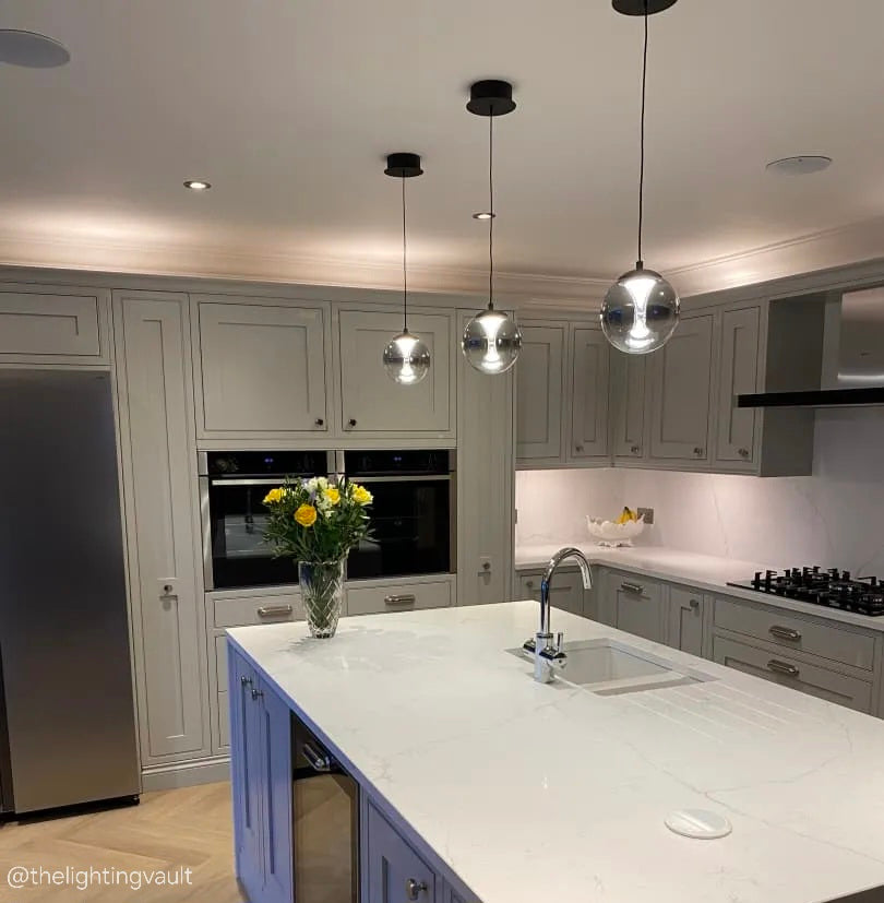 Havant single smoked glass pendant styled above a modern kitchen island with matte black accents.