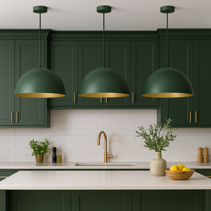 Green dome pendant lights with gold interiors above modern kitchen island with matching green cabinets and gold accents.