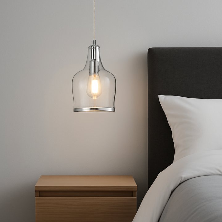 Horsham silver pendant light with clear glass shade hung beside a modern bed and wooden bedside table in a minimalist bedroom