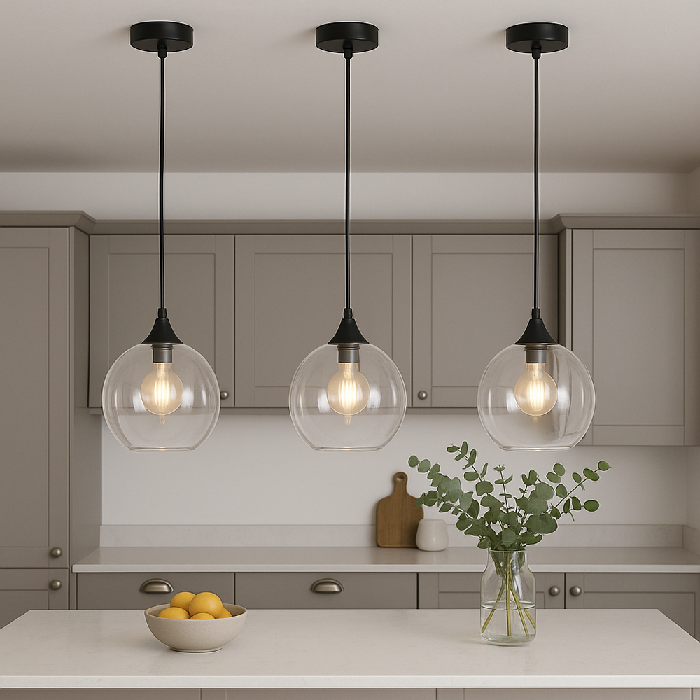 Modern kitchen with three Irvine clear glass pendant lights hung above a white marble island, styled with a bowl of lemons and a glass vase of eucalyptus for subtle luxury décor.