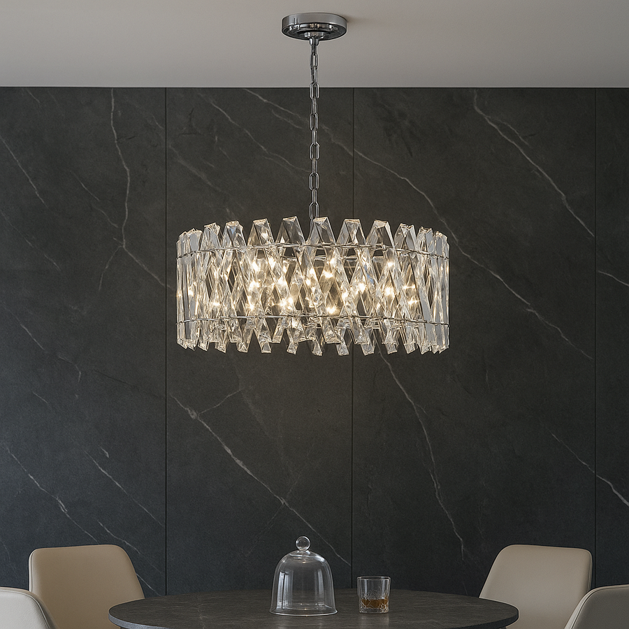 Luxury silver crystal chandelier hanging above a round dining table in a modern setting.