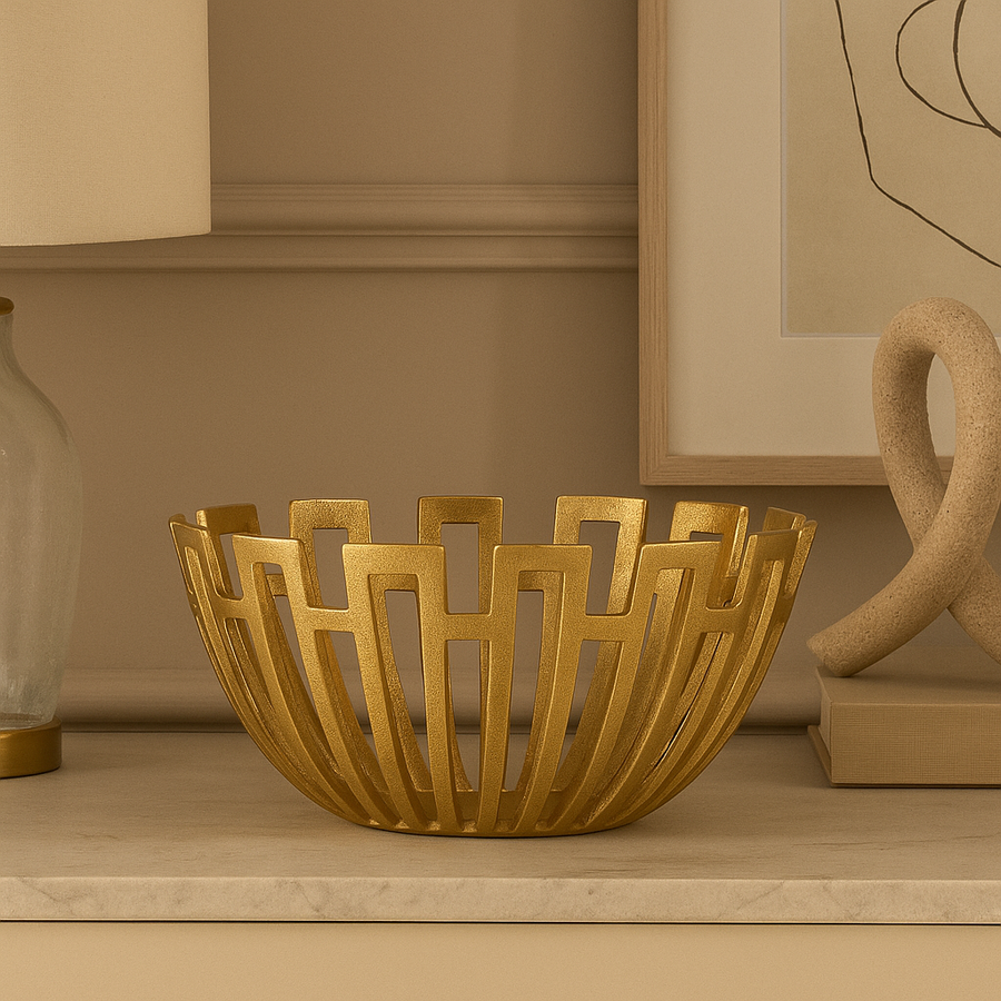 Luxury gold decorative metal bowl with open lattice design styled on marble surface in modern neutral living space