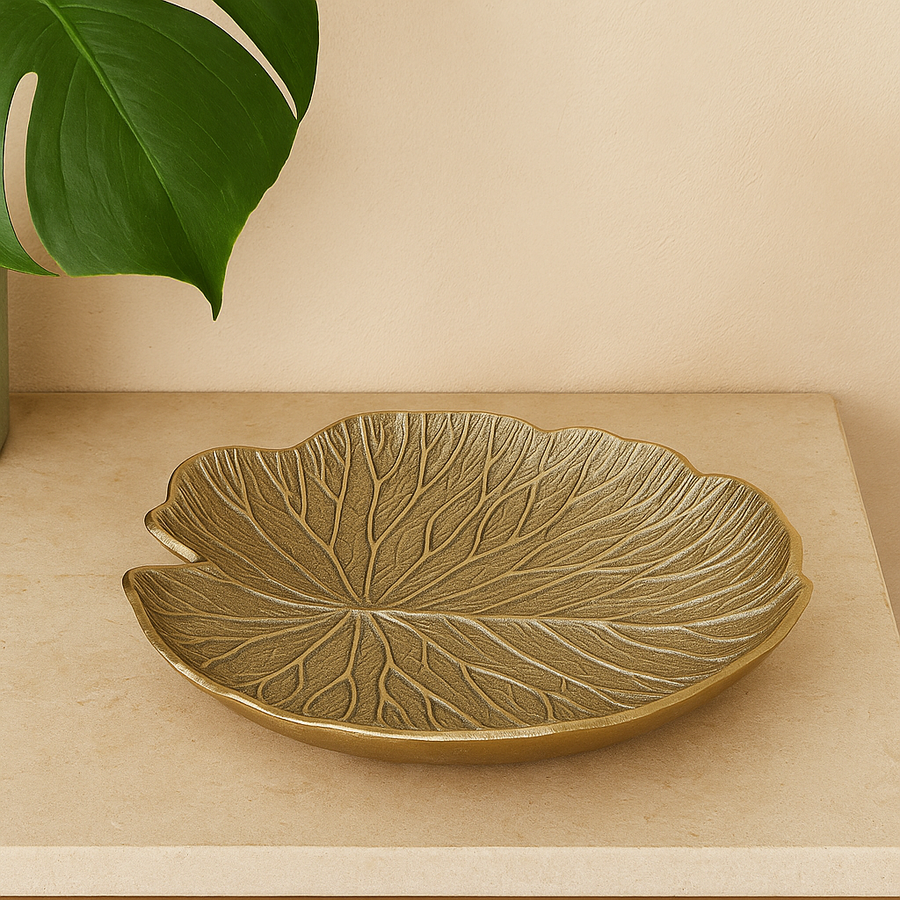Luxury gold metal leaf bowl in modern neutral lifestyle setting on marble surface