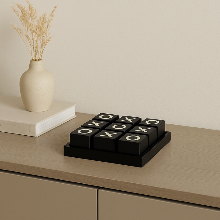Luxury black and cream noughts and crosses set on sideboard with vase and book