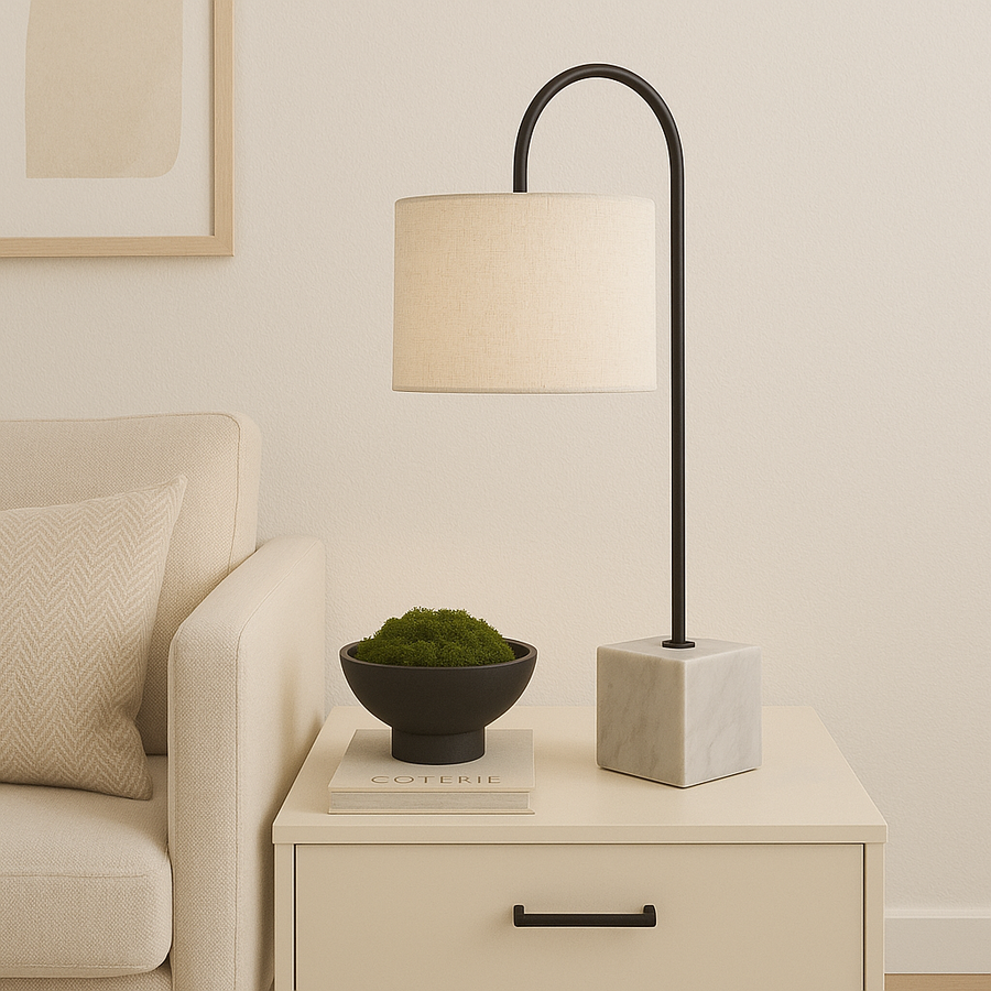 Scandinavian style living room with cream side table, modern table lamp with marble base and linen shade, styled with a black moss bowl and neutral sofa