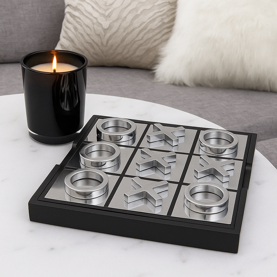 Luxury silver noughts and crosses game on white marble table with black glass candle