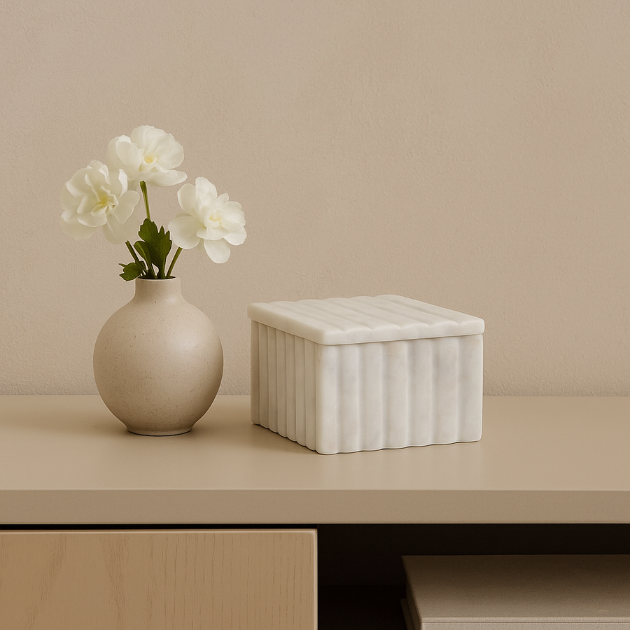 Luxury white marble box with vase of fresh white flowers on sideboard